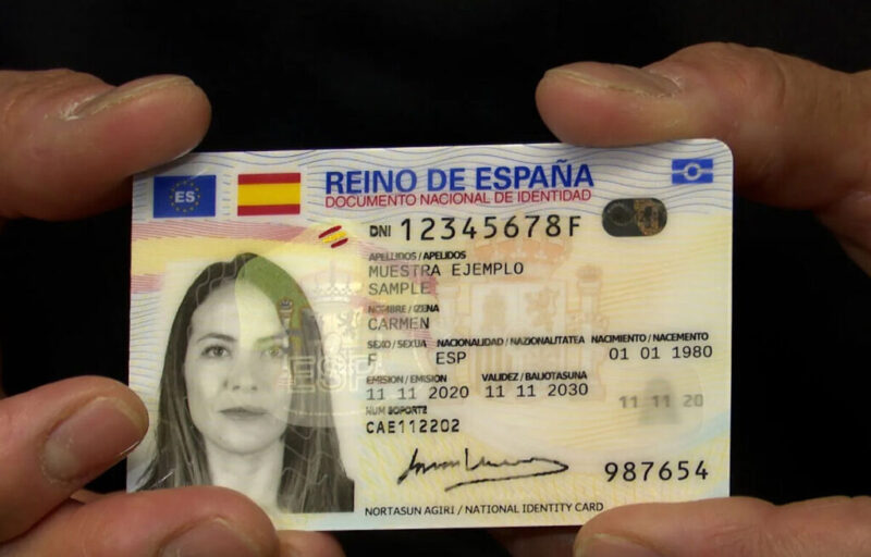 Una persona sostiene una muestra del Documento Nacional de Identidad (DNI) español, mostrando la cara frontal con detalles personales impresos, fotografía y elementos de seguridad.
